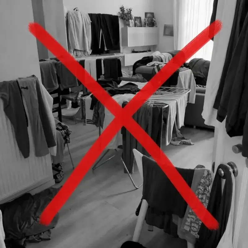 Cluttered living room with a bulky floor drying rack crossed out in red