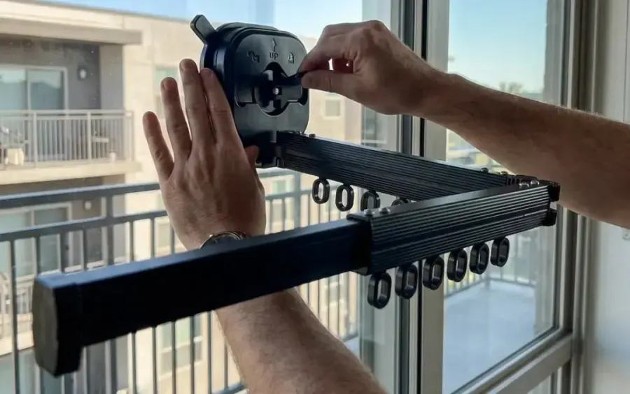 Hands locking the Qinux Hangeroox vacuum suction cup onto a balcony glass panel